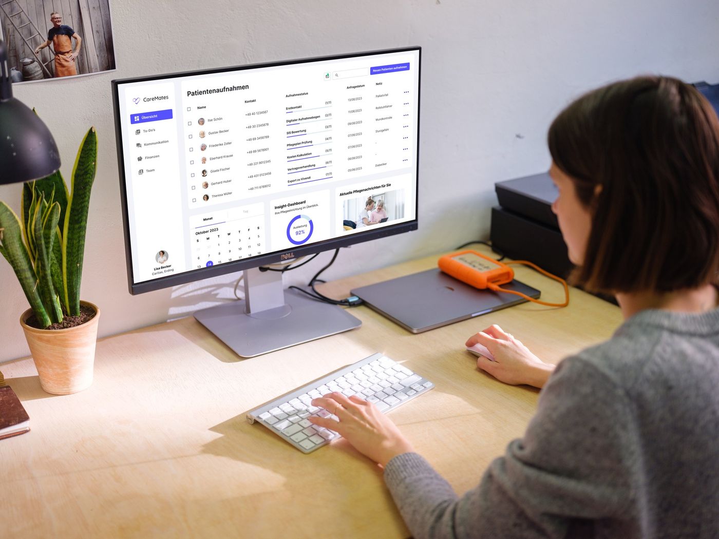 Care manager Lisa Becker at her desk using the CareMates patient admissions dashboard on a monitor, showing the admission status pipeline, calendar, and insight panel